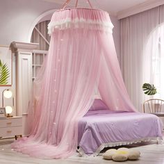 a pink canopy bed in a white bedroom