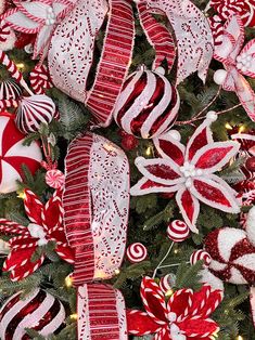 a christmas tree decorated with red and white ribbons