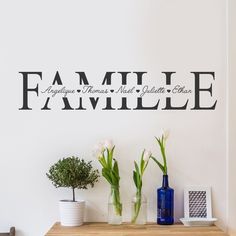 there is a wall decal that says family and flowers on the table next to it