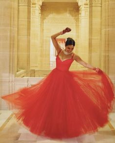 a woman in a red dress is dancing