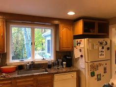 a kitchen with wooden cabinets and white refrigerator freezer next to a stove top oven