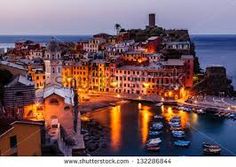 the city is lit up at night with boats in the water and buildings on both sides