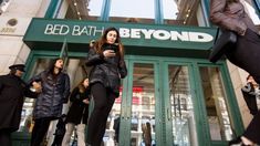 people are standing in front of a bed bath and beyond store