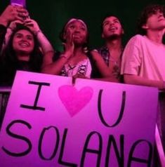 a group of people holding up a sign that says i love you solana