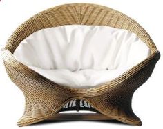 a wicker chair with white cushions on it