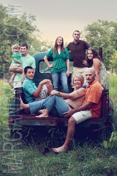 a group of people sitting in the back of a pick up truck with trees in the background