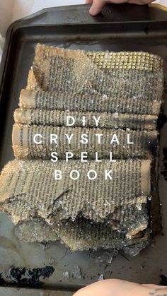 a person holding a tray with some kind of food on it that says diy crystal spell book