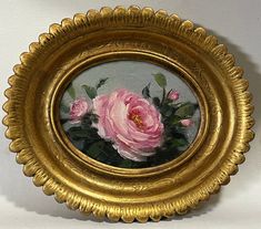 a painting of pink roses in a gold frame