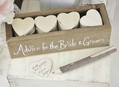 a wooden box filled with white hearts next to a knife and some writing on it