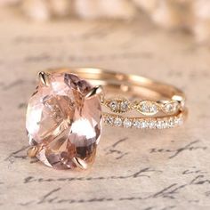 two wedding rings with an oval morganite and diamond band on top of a piece of paper