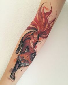 a woman's arm with a red fox tattoo on it