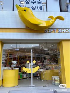 a store front with a yellow banana shaped object in the window and other items on display