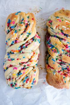 two pastries with sprinkles on them sitting next to eachother