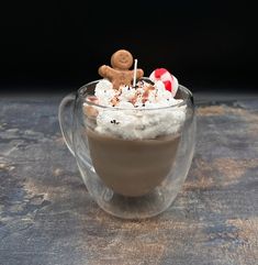 a glass cup filled with hot chocolate and marshmallows