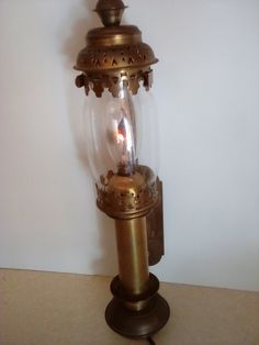 an old fashioned lamp with a candle in it