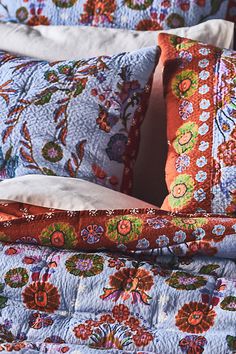 a bed with two pillows and an orange pillow