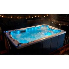 an indoor hot tub with blue lights on the sides