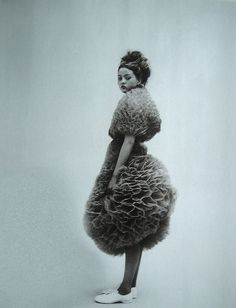 a black and white photo of a woman in a dress made out of fake fur