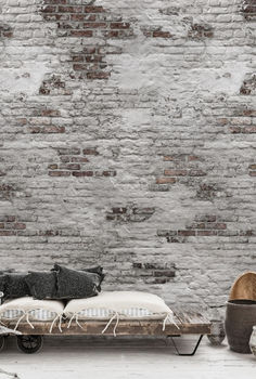 a bed sitting in front of a brick wall