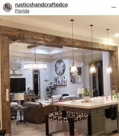 a kitchen and living room are reflected in the mirror on the wall above the bar