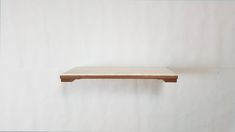 a wooden shelf sitting on top of a white wall