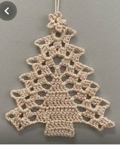 a crocheted christmas tree ornament hanging on a wall