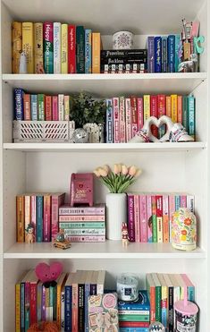 the bookshelves are filled with many different types of books and flowers in vases