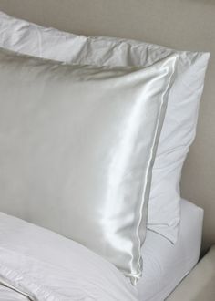 a white pillow and some pillows on a bed