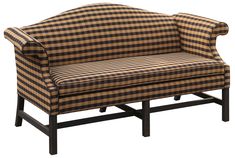 a brown and black checkered couch sitting on top of a wooden frame