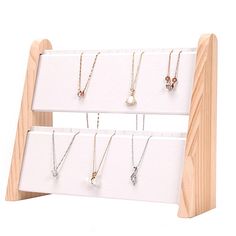 a wooden display with several necklaces on it