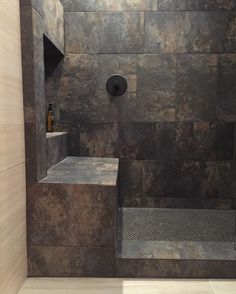 a walk in shower sitting inside of a bathroom next to a tiled wall and floor