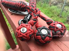 three red and black balls with numbers on them sitting on a wooden bench next to a pair of scissors