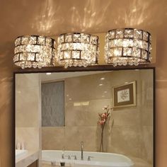 a bathroom with a bathtub and two lights on the wall above it in front of a mirror