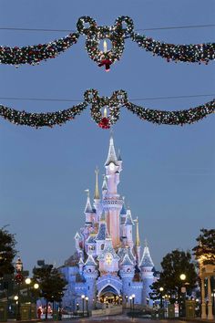 the castle is decorated for christmas with lights and garlands hanging from it's sides