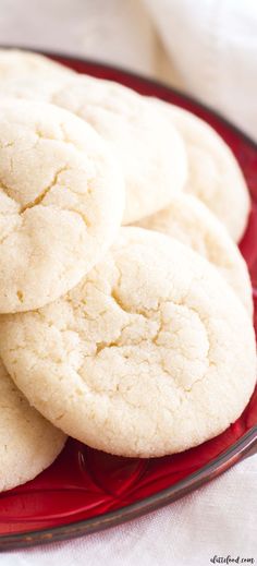 a red plate topped with white cookies on top of a table