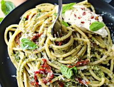 a plate of pasta with pesto and fettuccine