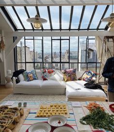 a living room filled with furniture and lots of food on top of a wooden floor