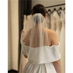 a woman in a wedding dress looking at her veil