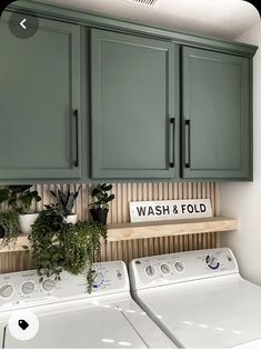 a washer and dryer in a room with green cabinets