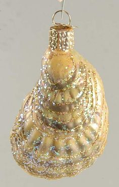 a glass ornament hanging from a hook on a string in the shape of a shell