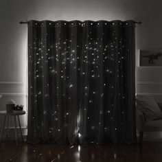 a black and white photo of a living room with stars on the curtain, light shining through