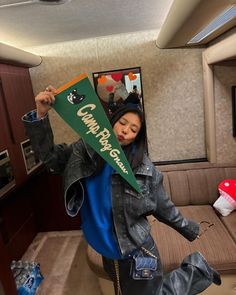 a woman sitting on top of a couch holding a green flag