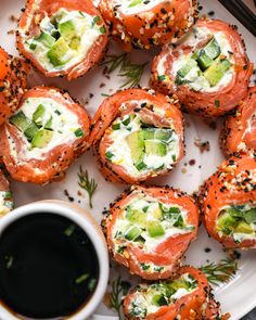 a white plate topped with sushi rolls next to a cup of coffee