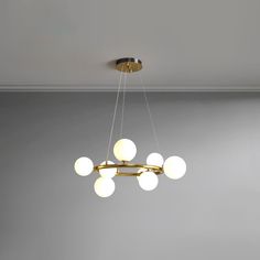 a chandelier hanging from the ceiling in a room with gray walls and flooring