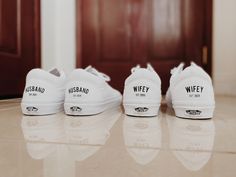 three pairs of white tennis shoes sitting on top of a counter