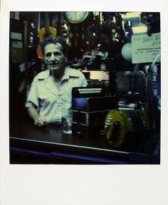 an old photo of a man sitting in front of a desk with a typewriter