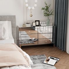 a bedroom with a mirrored dresser and bed