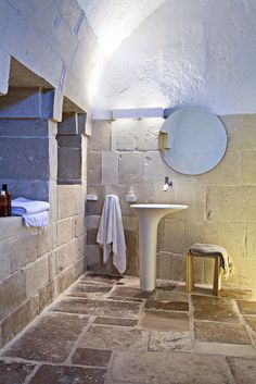 a bathroom with stone flooring and walls