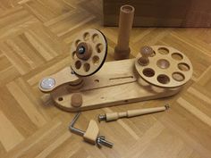 a wooden spinning wheel and other tools on the floor