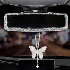 a car dashboard with a butterfly decoration hanging from it's center console